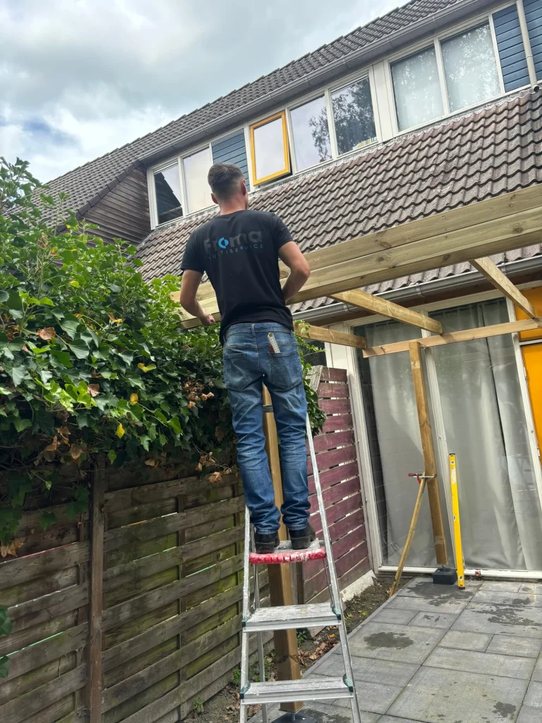 Medewerker bouwt een houten overkapping