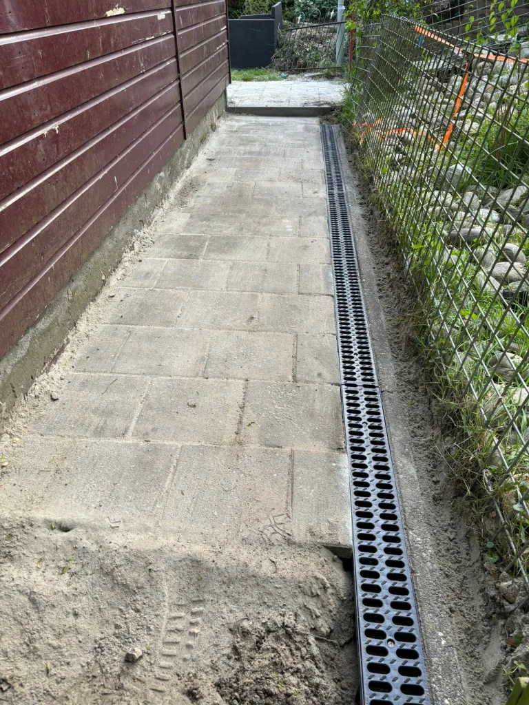 Nieuw tuinpad met bestrating en afvoergoot